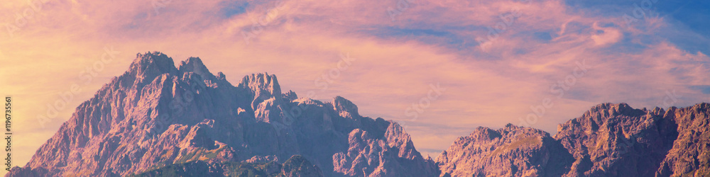 Silhouette of mountains against a sunset sky. Color gradient
