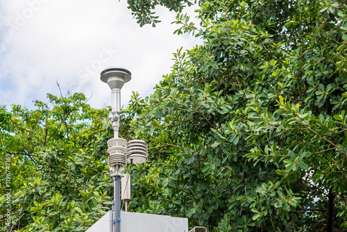 The Ambient Air Quality Monitoring System station with the tree back ground.