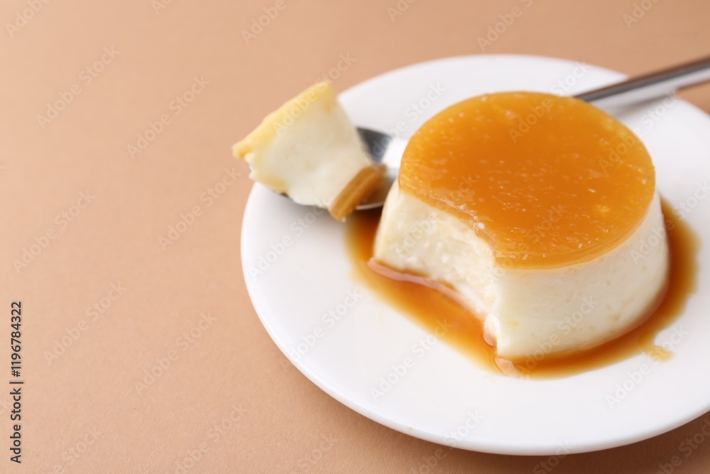 Tasty pudding with caramel sauce served on light brown background, closeup. Space for text Tasty pudding with caramel sauce served on light brown background, closeup. Space for text