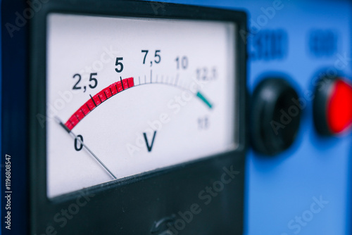 Close-up of a voltage meter displaying readings on a white dial with a red and green scale. Electrical equipment for monitoring voltage levels