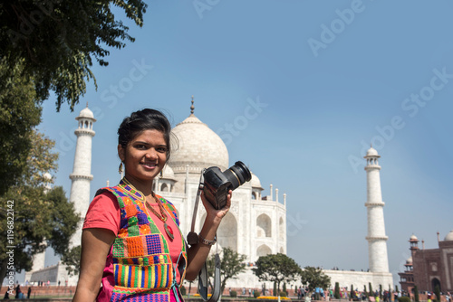 Canvas Print Young woman tourist taking photos of Taj Mahal,