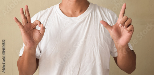Fotografia Young man view of pleased teacher showing alphabet letters on sign language