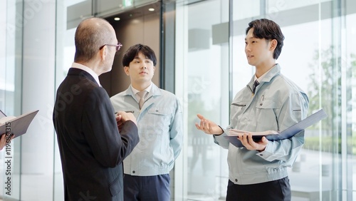 Cuadro en lienzo ロビーで話をするビジネスマンと作業服を着た男性