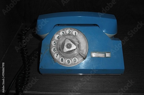 Vintage blue rotary phone displayed on wooden surface in a nostalgic setting photo