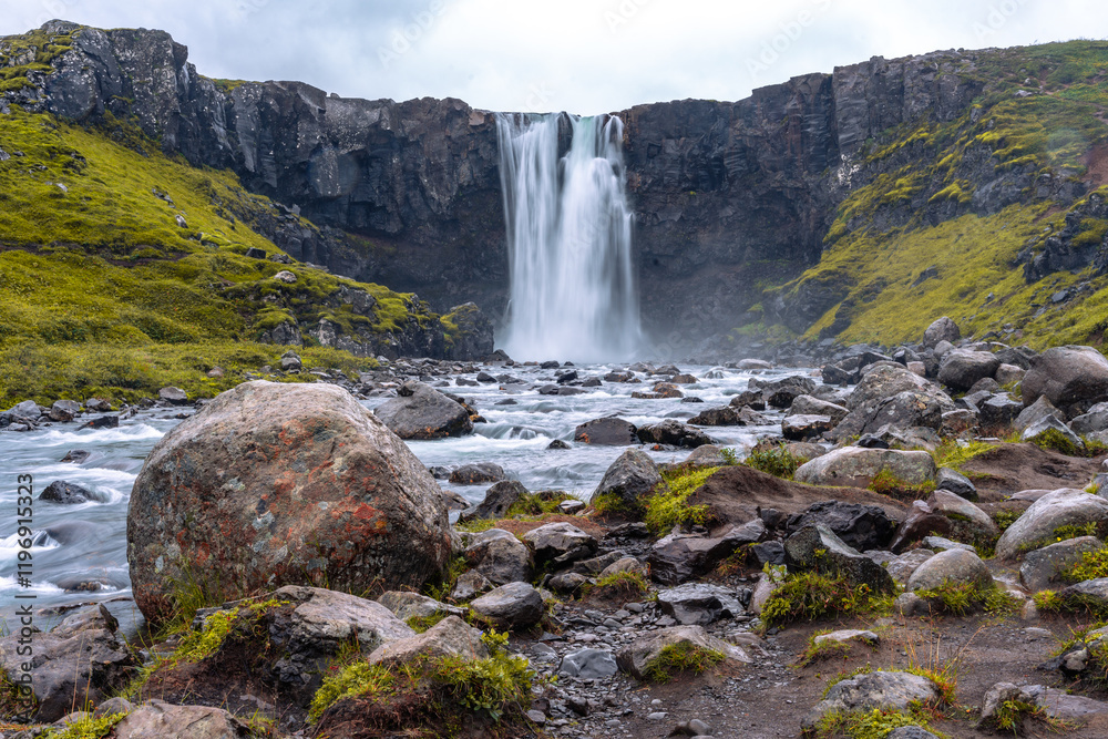 A scenic view of Gufufoss waterfall and the tranquil Fjarðará river, located close to Seyðisfjörður in Iceland's eastern region A scenic view of Gufufoss waterfall and the tranquil Fjarðará river, located close to Seyðisfjörður in Iceland's eastern region