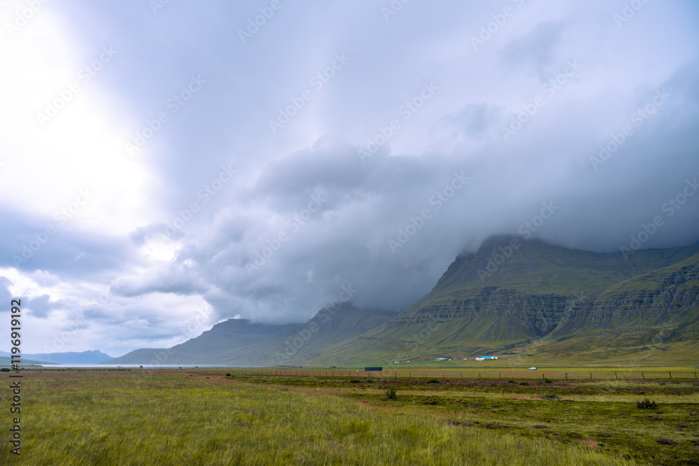 The mystically beautiful landscape of eastern Iceland near Reydarfjordur, with steep mountains and dramatic cloud formations The mystically beautiful landscape of eastern Iceland near Reydarfjordur, with steep mountains and dramatic cloud formations