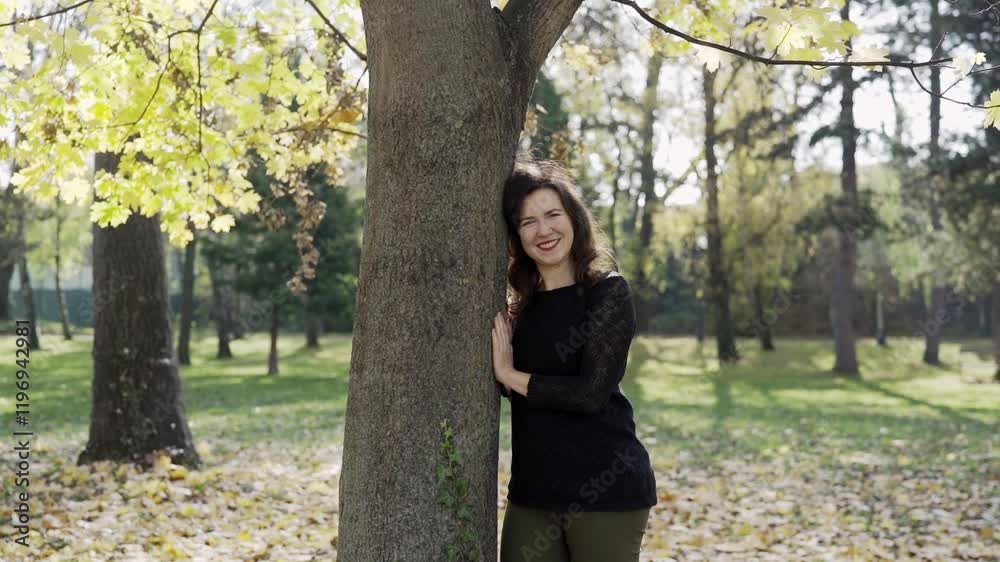 Woman leans against tree in forest, smiling and enjoying the moment. Relaxation and mental health conept Woman leans against tree in forest, smiling and enjoying the moment. Relaxation and mental health conept