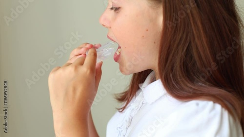 A young girl demonstrates how to put on and showcase her orthodontic retainer designed to correct her bite and improve her smile. This close-up footage provides insights into the importance of dental 