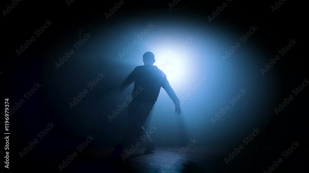Silhouette of a man dancing break dance in a dark studio Dancer artist performing. High quality 4k footage