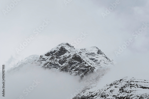 felsige schneebedeckte Gipfel wolkenumhüllt