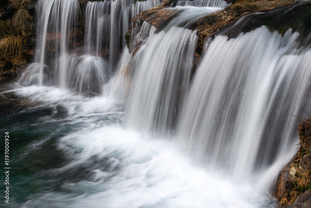 Mesmerizing waterfall cascading over rocky terrain, with silky smooth water flows creating a serene and tranquil nature scene, perfect for landscape lovers. Mesmerizing waterfall cascading over rocky terrain, with silky smooth water flows creating a serene and tranquil nature scene, perfect for landscape lovers.