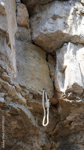 Kletterhaken mit Seil  am Überhang einer Felswand