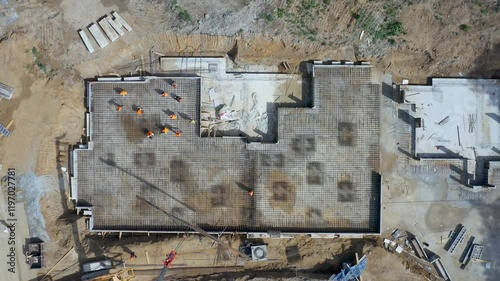 A highangle shot captures ongoing construction activity that is in progress on a large and sturdy foundation base