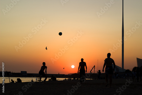 People playing ball on the beach at sunset. St. Petersburg