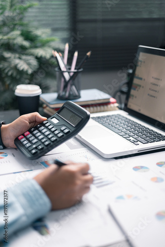 Finance bank tax expense accounting budget money businessman hand use calculator Financial calculate accountant close up calculator with graph chart write office desk Business expense analysis saving
