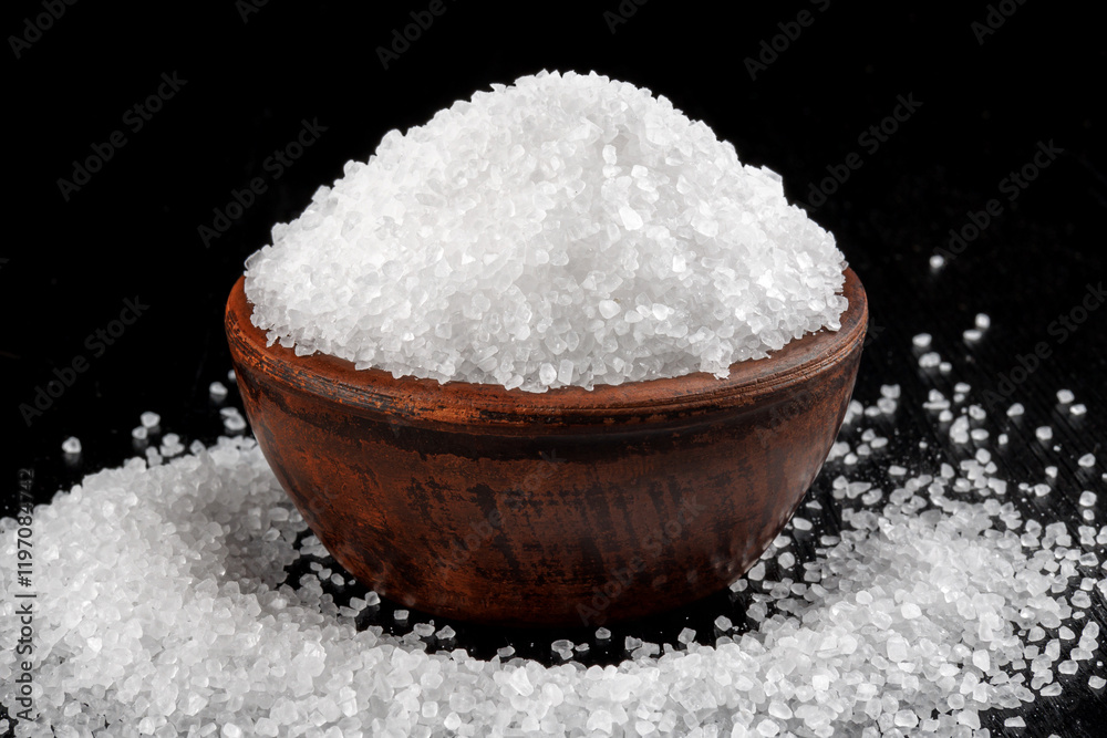A clay cup with salt and salt sprinkled around it. table salt. A clay cup with salt and salt sprinkled around it. table salt.
