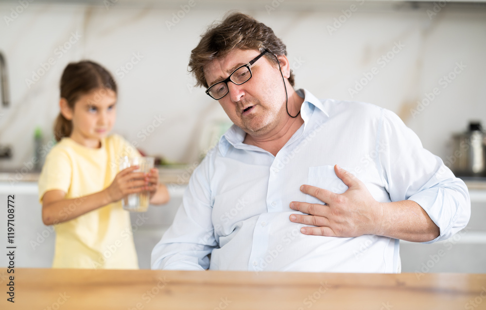 Obraz premium Daughter gives water to father whose heart hurts