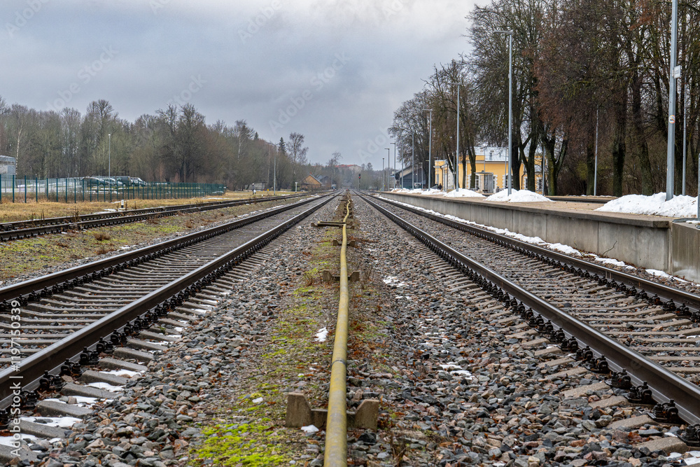 Fototapeta premium Railway Tracks and Signal in Winter Landscape. Low Angle View of Railway Tracks in Rural Area. 15.01.2025. Cesis. Latvia.