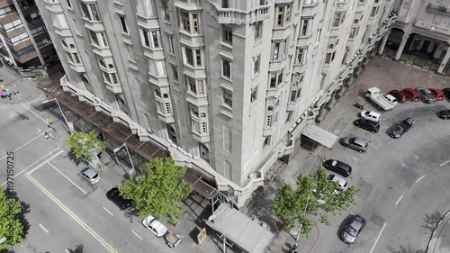 Drone rises with camera pointing down at the bottom corner of Palacio Salvo, rising to the top of the building in Montevideo, Uruguay