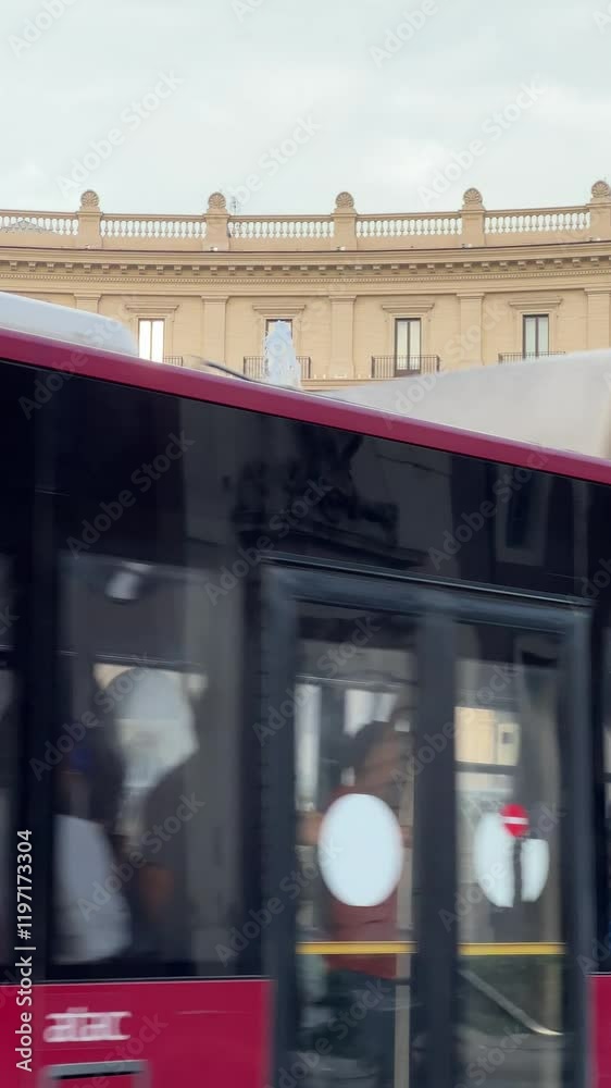 Rome, Italy - 05 09 2024: Italian antique fountain in Rome center with an urban red bus passing in front of the camera