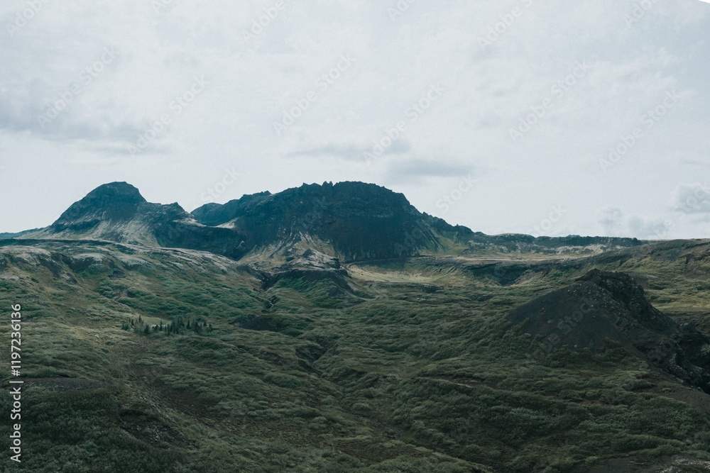 Rugged green hills and volcanic mountains in Thingvellir National Park, Iceland.