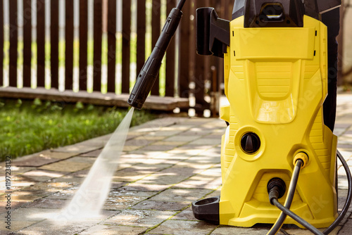 Pressure Washer Karcher in Home Garden. High Pressure Cleaning Garden Path Paving Stones with Power Cleaner. Cleaning Service. Water Jet Close up.
