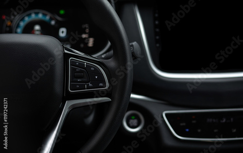The steering wheel of a car is black and has a digital display