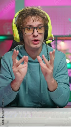 Young gamer plays game with friends online on the internet. Chats about the game. 
Wins tournament and is very happy. Happy young eSports player.