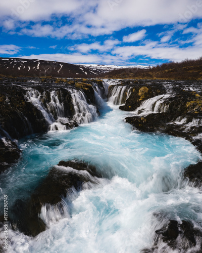 Bruarafoss waterfall with stunning turquoise waters under a bright sky in south Iceland