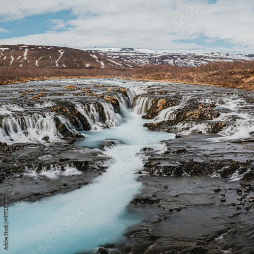 Bruarafoss waterfall with stunning turquoise waters under a bright sky in south Iceland photo