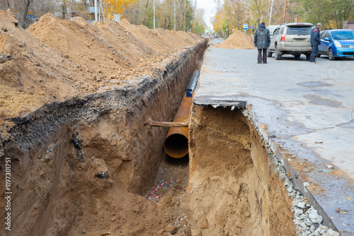 A large diameter water pipe 100 meters long in a earthen trench under the asphalt street surface. Repair, renovation or replacement of municipal equipment in the city