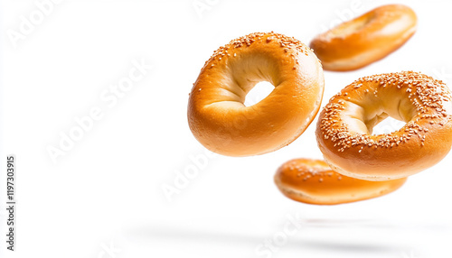 Delicious flying bagels with sesame seeds on a white background. photo