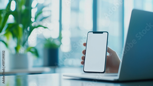 In a sleek office setting, hands operate a smartphone while referencing data on a laptop, symbolizing the integration of mobile and desktop technology for enhanced productivity, sm photo