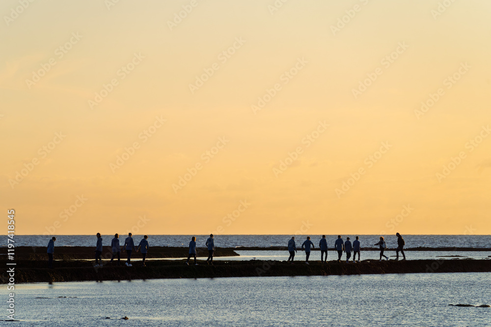 Obraz premium Menschen im Sonnenuntergang am Strand von Rota, Stadt im Südwesten, Spanien, Andalusien in der Provinz Cádiz / Costa de la Luz