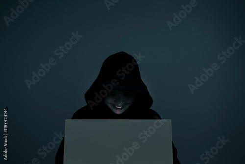 어두운 공간에서 미소 짓고 있는 후드를 입은 청년