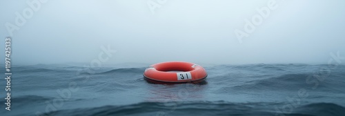 A red life preserver is floating in the water. The water is calm and the sky is cloudy