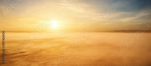 Sunrise over misty landscape with warm golden hues and soft clouds against a clear blue sky Copy Space photo