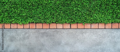 Green grass border with red brick pathway against a smooth concrete surface, featuring ample copy space for text insertion. photo