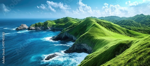 Vibrant green hills meeting a clear blue ocean under a bright sky, with expansive space for overlaying text or graphics in the foreground. photo