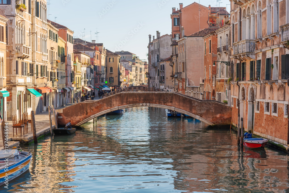 Fototapeta premium Picturesque Venetian Canal with Stone Bridge and Boats