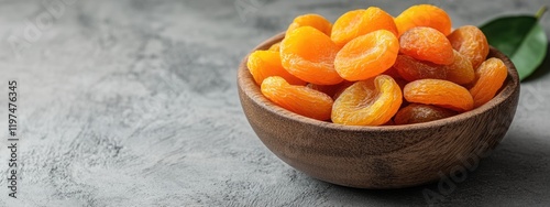 Dried apricots in wooden bowl on gray background with copy space for text photo