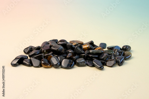 macro shooting of natural mineral stone - tumbled hawks eye gemstone isolated on light background photo