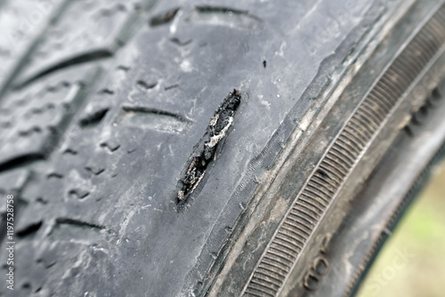 Worn-out car tire with damaged sidewall photo