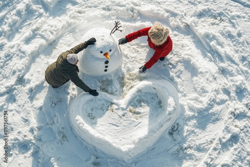 A couple joyfully builds a snowman surrounded by snow, while shaping a large heart in the snow, capturing a moment of love and playfulness in a winter landscape. photo