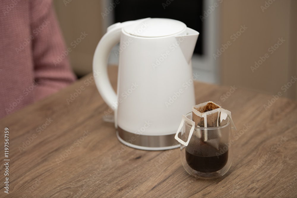 Obraz premium Delicate hand-crafted drip coffee preparation using a sleek kettle in a cozy setting