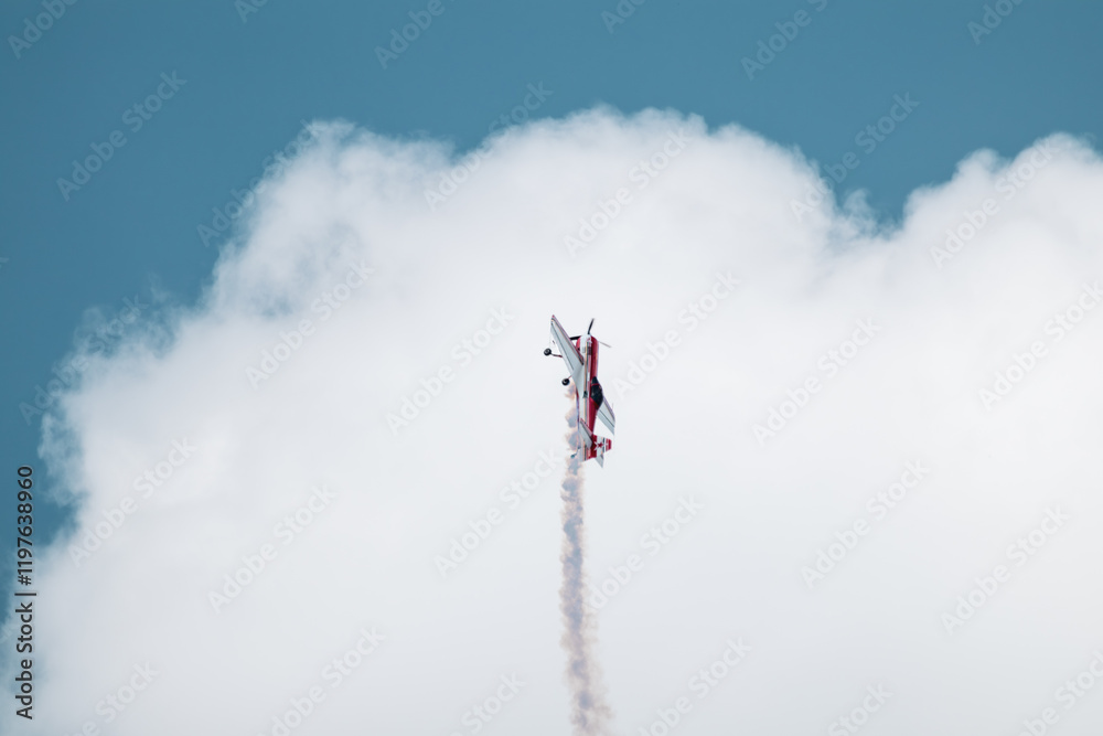 Light red Sukhoi Su-31 aircraft plane performing stunts in cloudy sky on airshow Light red Sukhoi Su-31 aircraft plane performing stunts in cloudy sky on airshow