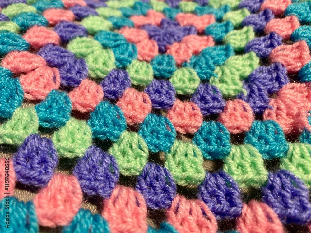 Granny square crocheted blanket with different colors motives, retro vintage craft handmade handiwork crocheting, beautiful plied photo cozy winter or autumn background wool thing yarn lovely warm Granny square crocheted blanket with different colors motives, retro vintage craft handmade handiwork crocheting, beautiful plied photo cozy winter or autumn background wool thing yarn lovely warm