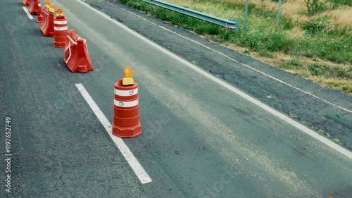 Road construction with safety cones marking work zone on highway