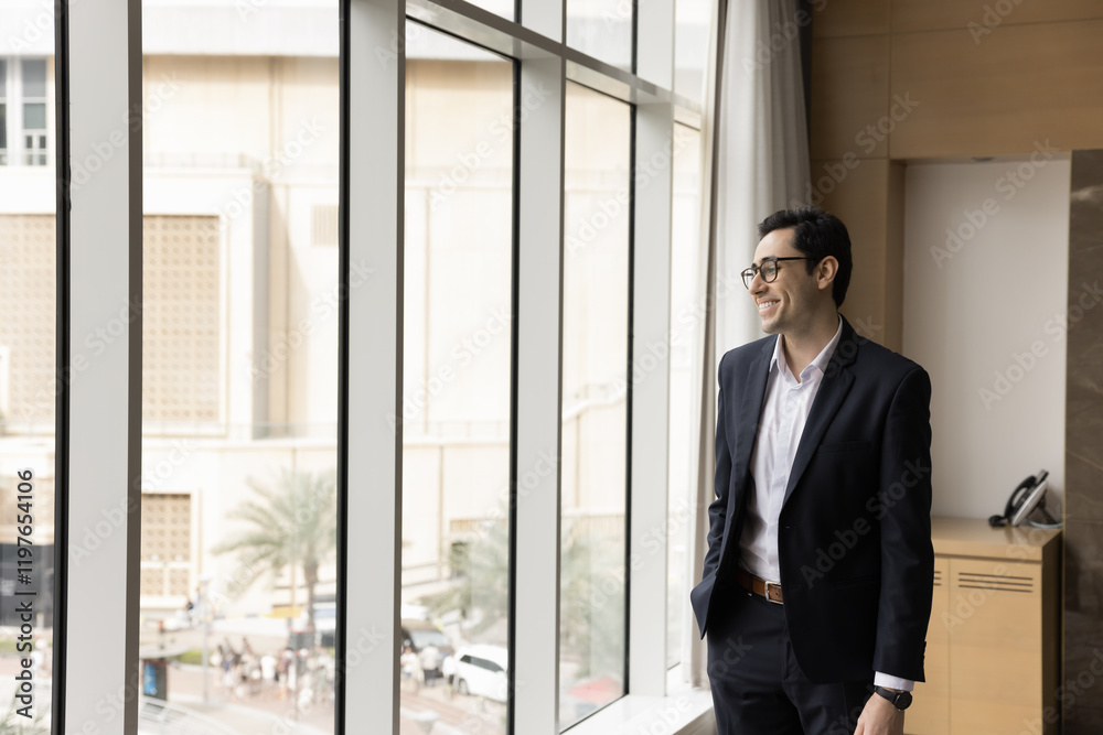 Happy Arabian company boss take break standing in modern office workspace looks out window with positive expression, deep in thoughts, ponder on achievements and success. Business, future, aspirations Happy Arabian company boss take break standing in modern office workspace looks out window with positive expression, deep in thoughts, ponder on achievements and success. Business, future, aspirations