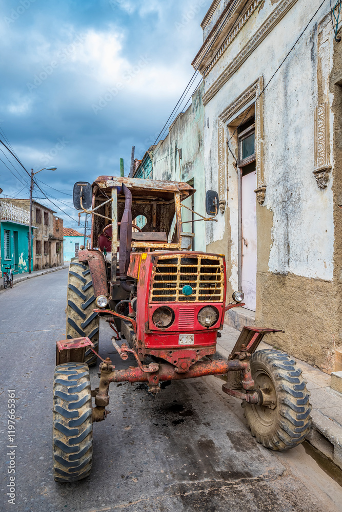 old, rusty red tractor parked on a street